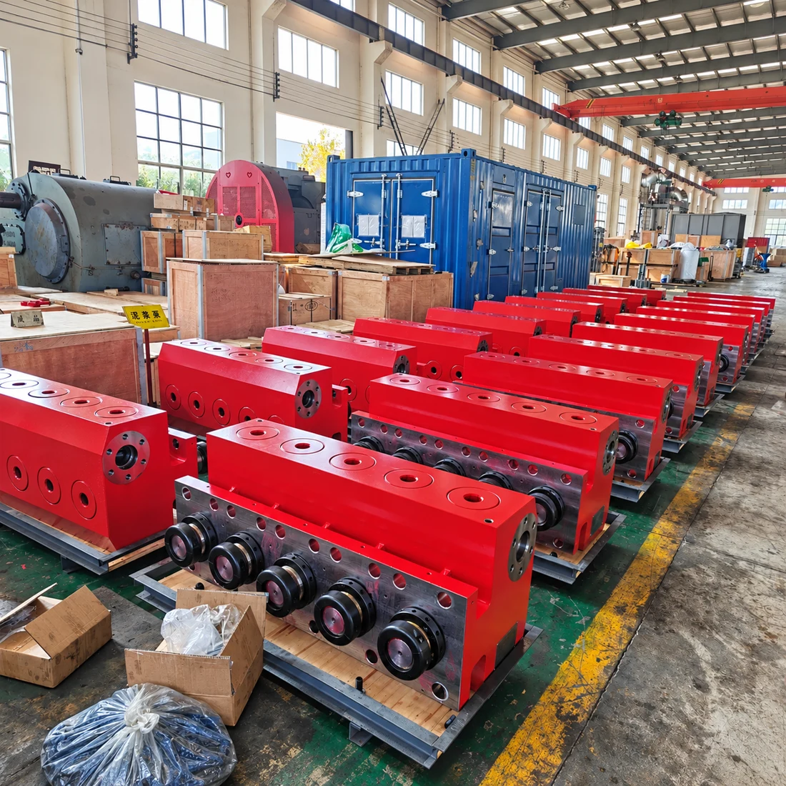 Rows of red fluid-end assemblies in the manufacturing workshop